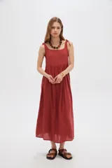 Vestido midi negro de viscosa con cuello cuadrado y tirantes finos ajustables con lazo en los hombros, de corte holgado y diseño fluido.
