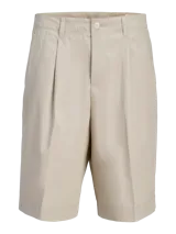 Short color beige de tiro medio con cierre de cremallera, bolsillos delanteros y traseros.