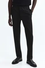 Pantalón tipo jogger de vestir, corte slim fit, con cintura elástica y cordón de ajuste. Presenta pliegues frontales y traseros, bolsillos laterales al bies y bolsillos traseros insertados.