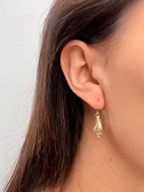 Par de aros colgantes dorados con forma de concha marina.