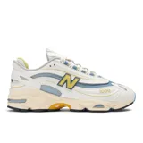 Championes New Balance modelo 1000, color blanco con detalles en celeste y amarillo. Capas subyacentes de malla y superposiciones sintéticas, entresuela combinada de poliuretano y ABZORB, con amortiguación ABZORB en el talón y el antepié.