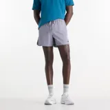 Short de running New Balance RC Essential de color gris, con cintura elástica y cordón ajustable, aberturas laterales y logo de la marca en la pierna izquierda.