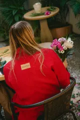 Tapado largo de paño color rojo, confeccionado con mezcla de lana, con solapas amplias, bolsillos laterales y cierre cruzado.