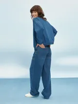 Campera bomber de denim azul con cierre frontal, bolsillos laterales y elástico en puños y cintura.
