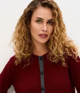 Cardigan de punto Marfinno, color negro con detalles en blanco en la botonera y el ruedo. Presenta cuello redondo, mangas largas y cierre frontal con botones oscuros.