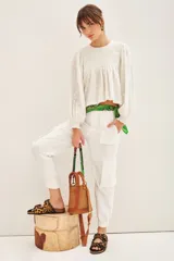 Pantalon tipo cargo color blanco, de corte holgado, con bolsillos laterales y en las piernas, cintura con elástico y puños elásticos en el ruedo.