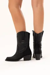 Bota de caña media con diseño estilo western, confeccionada en cuero con acabado texturado tipo craquelado. Cuenta con taco medio y tiradores laterales para facilitar el calce.