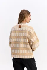 Sweater de punto con diseño de cuadros en tonos beige y crema, de silueta relajada, cuello redondo y mangas largas con puños elásticos.