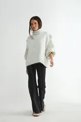 Chaleco de punto gris con cuello alto, diseño sin mangas y corte holgado.