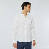 Camisa blanca de lino con cuello mao, manga larga con puños abotonados y bolsillo de parche en el pecho. Cierre frontal con botones a tono.