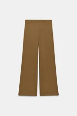 Pantalón de tiro medio color tostado, con pernera recta, trabillas para cinturón y cierre frontal con cremallera y botón oculto.