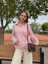 Cartera bandolera de cuero color chocolate, con solapa frontal decorada con costuras artesanales a la vista. Cuenta con correa larga ajustable y herrajes metálicos en tono bronce.