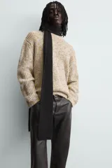 Jersey de punto con textura acanalada y diseño jaspeado en tonos beige y amarillo. Presenta un corte relajado, cuello redondo y mangas largas con acabados en rib.