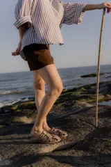 Sandalias bajas color beige con tiras de cuero entretejidas.