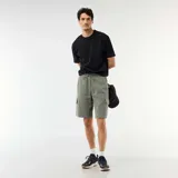 Bermuda verde militar de piqué de algodón con bolsillos cargo laterales y cordón ajustable en la cintura.