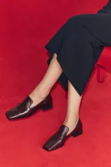 Mocasines de piel color marrón con copete subido, tacón medio en bloque y punta cuadrada.