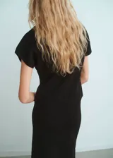 Jersey de punto fino color negro, con cuello redondo, manga corta y diseño entallado.