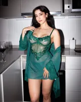 Babydoll de encaje verde oscuro con transparencias, tirantes finos y detalle de moño en el centro del escote. Incluye bata a juego con mangas anchas de encaje y tanga hilo.