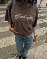 Remera marrón oversize de manga corta con estampado gráfico en la espalda de dos gatos de estilo retro con cuchillos y texto "Kahoa Industries".