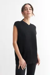 Chaleco negro de punto con cuello en V y sisas amplias.