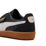 Championes Puma modelo Palermo LTH, de diseño clásico con base de cuero blanco, detalles en gamuza gris y la icónica franja lateral en negro. Presenta una suela de goma color caramelo y el logo de la marca en el lateral.