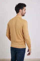 Polera de punto color tostado, de corte ajustado, mangas largas tipo raglán y cuello alto acanalado.