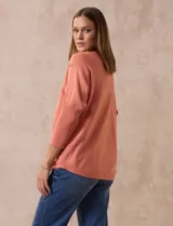 Buzo tejido color salmón de hilado fino, marca Cable & Gauge. Escote redondo con calados. Manga ¾, modelo dolman con aplique de botones dorados.