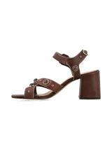 Sandalias de taco cuadrado alto y color marrón chocolate, con tiras anchas en el empeine decoradas con tachas metálicas y tira ajustable con hebilla en el tobillo.