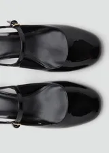 Zapato destalonado de tacón bloque bajo, con acabado efecto charol, puntera redondeada y cierre de hebilla ajustable.