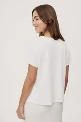 Remera de manga corta y cuello redondo color blanco, con estampa frontal multicolor de ilustraciones de estilo gráfico.