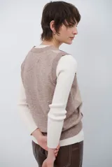 Chaleco de punto con diseño de rombos en tonos beige, marrón y gris. Presenta cuello redondo y corte ajustado a la cintura.