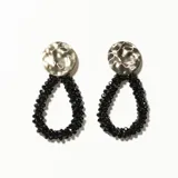 Aros colgantes con base circular plateada texturada y cuentas negras formando una gota.