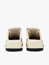 Zapatilla mule de cuero blanco y negro, con cordones y logo de la marca en el lateral.