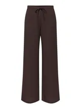 Pantalón suelto color marrón con estampado de lunares blancos, tiro medio y cintura elástica con cordón de ajuste.