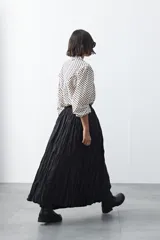 Falda larga de silueta amplia y caída fluida, con cintura elástica y textura arrugada.