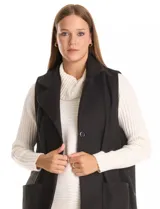 Chaleco largo de paño marca Barrington, color negro, con cuello solapa, cierre frontal con botones y bolsillos delanteros aplicados.