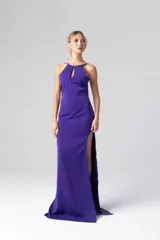 Vestido largo de fiesta color violeta, con escote halter con abertura en el pecho y tajo lateral en la pierna.