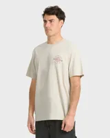 Remera Billabong de manga corta y corte regular, color beige, con gran estampado gráfico en la espalda que incluye el texto "Billabong", la ilustración de una quilla de tabla de surf y un sol estilizado.