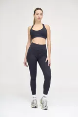 Top deportivo negro con escote redondeado, espalda cruzada y cintura con doble tela.