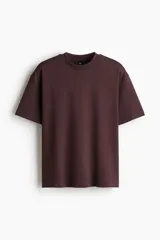 Remera de algodón pesado color marrón, con cuello redondo ribeteado, hombros caídos y corte holgado.
