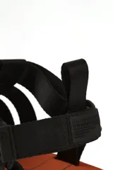 Sandalias negras con tiras anchas de ajuste con velcro, base marrón y suela blanca con diseño geométrico.