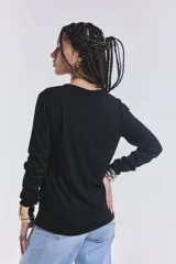 Remera básica de manga larga en color negro, con textura acanalada y cuello redondo.
