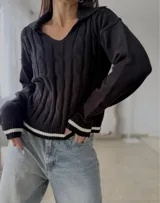 Sweater de punto con diseño de trenzas, cuello en V con solapa tipo polo, manga larga y puños con detalle de franja negra en contraste.