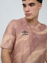 Remera deportiva Umbro modelo Niso, de manga corta y cuello redondo, con estampado abstracto en tonos negro y gris, y logo de la marca impreso en el pecho.