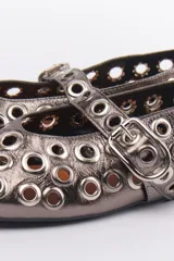 Ballerinas negras de cuero sintético con correa sobre el empeine y hebilla metálica. Diseño con múltiples ojalillos metálicos.