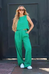 Pantalón verde esmeralda de lino, con pinzas frontales, bolsillos y cintura elástica.