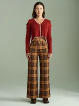 Saco de punto acanalado color bordó con detalles en color crudo en el cuello, plaqueta de botones y ruedo. Presenta aberturas en los hombros y cierre frontal con botones pequeños.