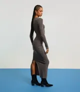 Vestido midi gris confeccionado en rib de algodón y elastano. Posee cuello redondo, manga larga y drapeado lateral con abertura en la parte inferior.
