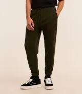 Pantalón tipo jogger de corte holgado, color verde oliva, con cintura elástica ajustable mediante cordón, bolsillos laterales y puños elásticos en los tobillos.