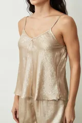 Conjunto de pijama plateado brillante, compuesto por un top de tirantes con escote en V y shorts sueltos.